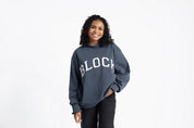 Person wearing a navy blue sweatshirt with 'BLOCK' in tackle twill 