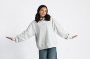 Girl wearing a gray sweatshirt with 'BLOCK' in tackle twill in white lettering