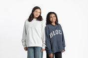 Two volleyball players wearing 'BLOCK' sweatshirts on a white background