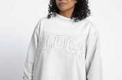 Volleyball player wearing a gray mockbeck sweatshirt with 'Block' text 