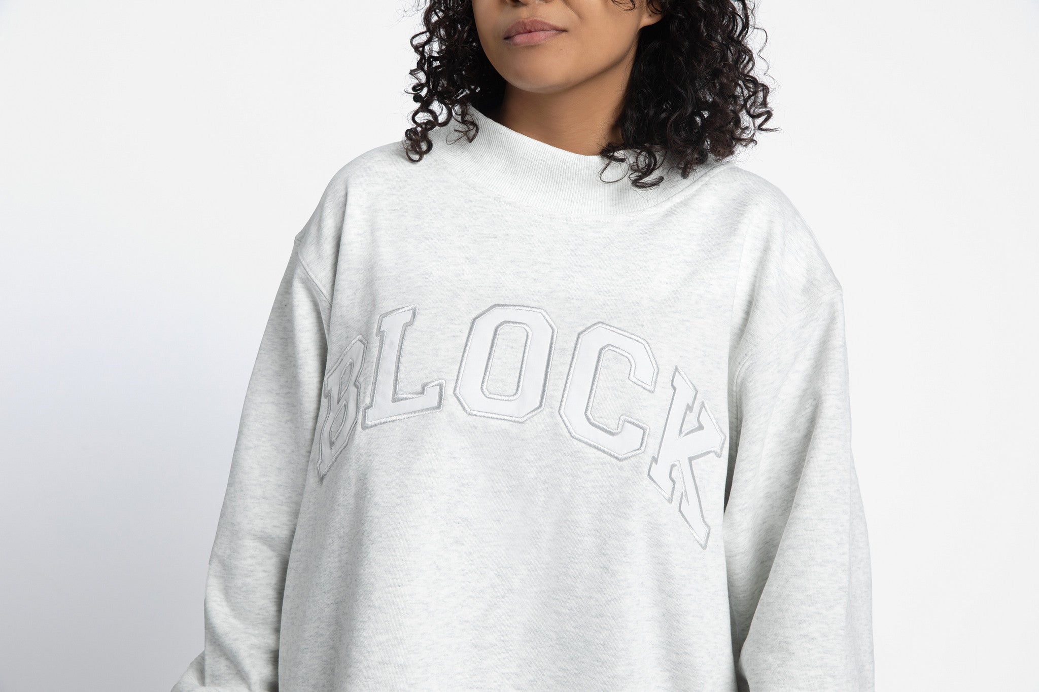 Volleyball player wearing a gray mockbeck sweatshirt with 'Block' text 
