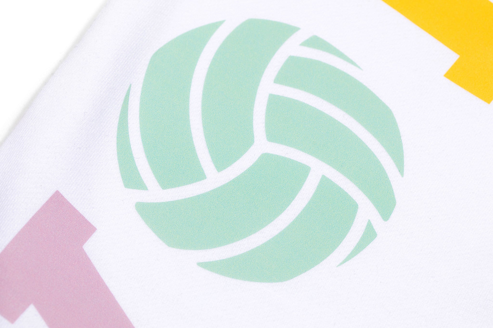 Close up detail shot of a green volleyball design on a white sweatshirt